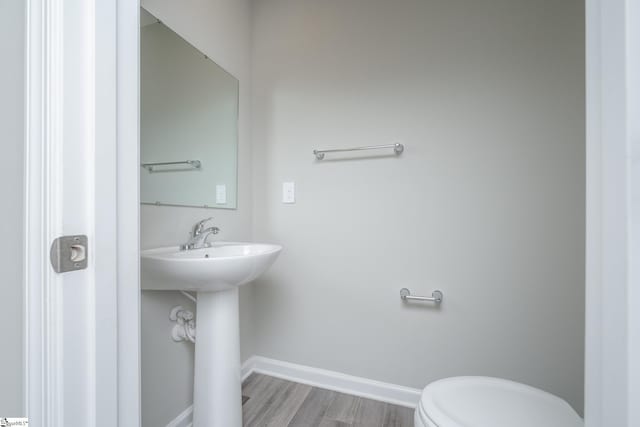 bathroom featuring hardwood / wood-style floors and toilet