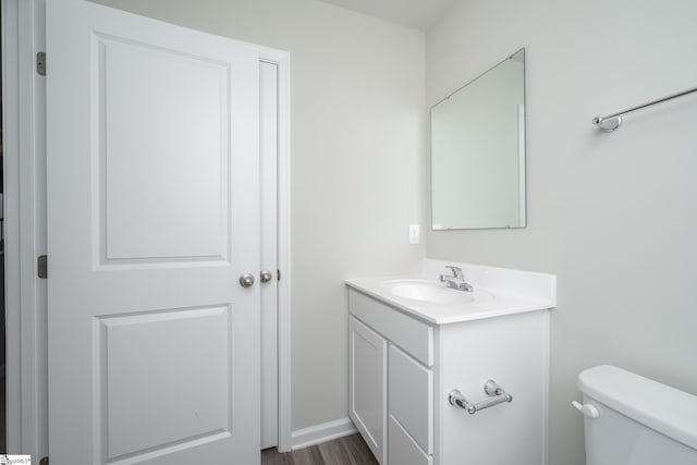 bathroom with vanity, toilet, and wood-type flooring