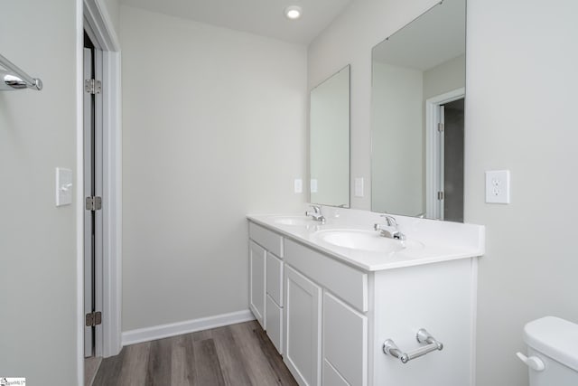 bathroom featuring toilet, vanity, and hardwood / wood-style flooring