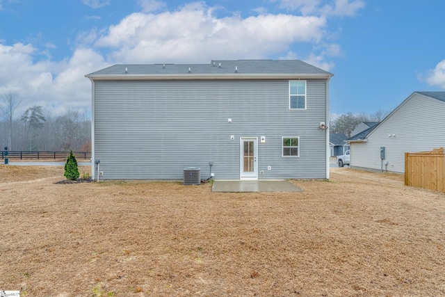 back of property with central air condition unit and a patio