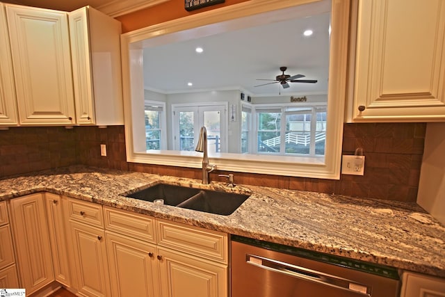 kitchen with light stone countertops, sink, stainless steel dishwasher, and ornamental molding