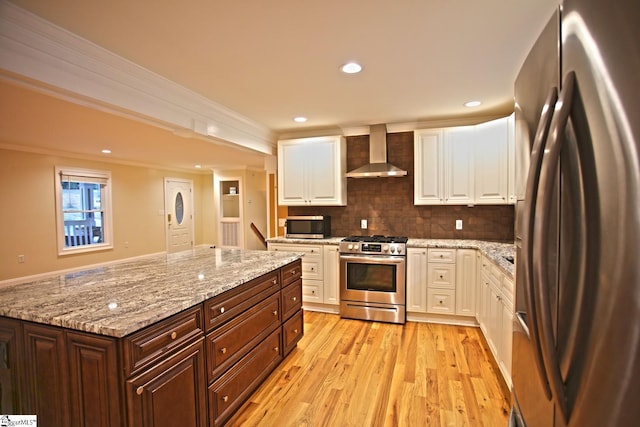 kitchen with backsplash, crown molding, wall chimney exhaust hood, dark brown cabinets, and stainless steel appliances