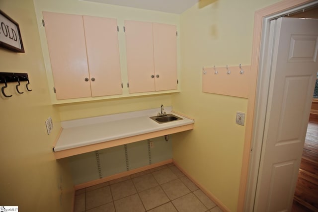 clothes washing area featuring sink and light tile patterned floors