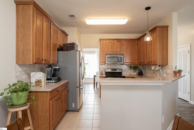 kitchen featuring kitchen peninsula, tasteful backsplash, a breakfast bar, stainless steel appliances, and light tile patterned floors