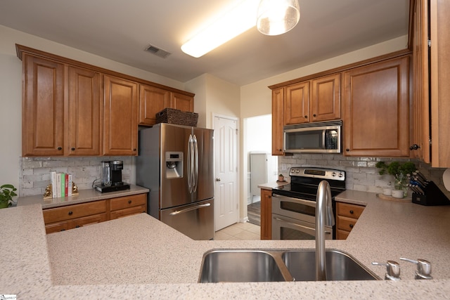 kitchen featuring backsplash, light tile patterned floors, and appliances with stainless steel finishes