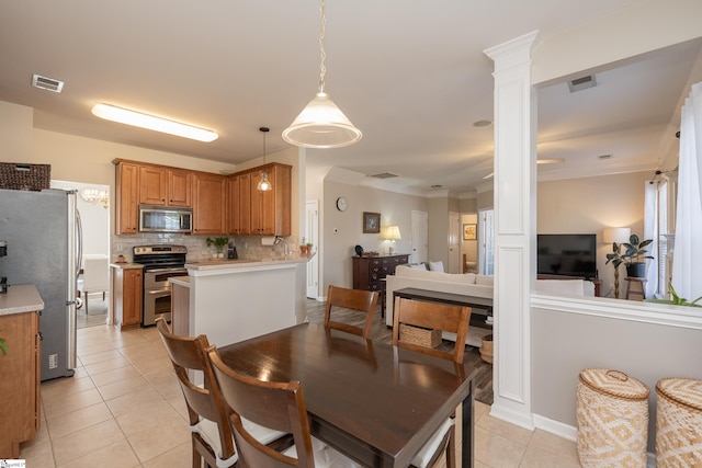 dining area featuring ornate columns, ornamental molding, and light tile patterned flooring