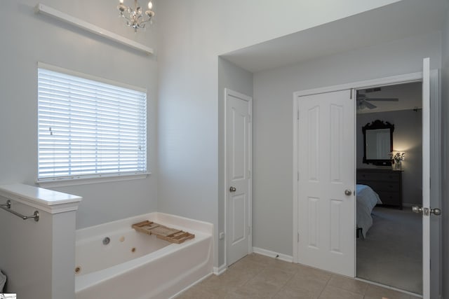 bathroom featuring tile patterned floors, a bath, and ceiling fan with notable chandelier