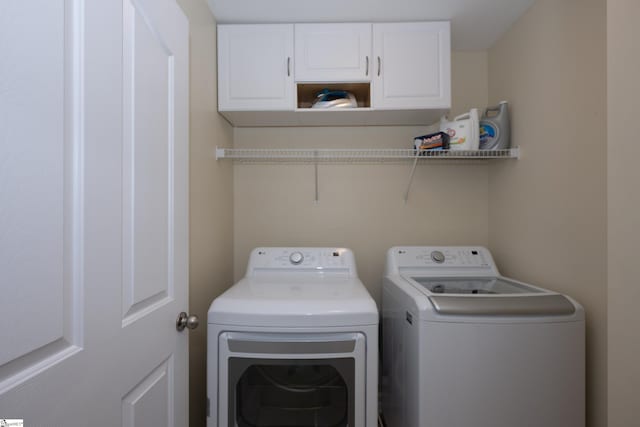 laundry area featuring cabinets and washer and clothes dryer