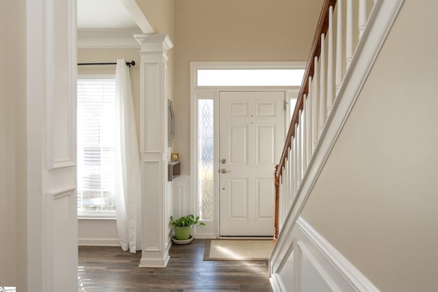 entrance foyer featuring ornate columns, crown molding, and dark hardwood / wood-style floors