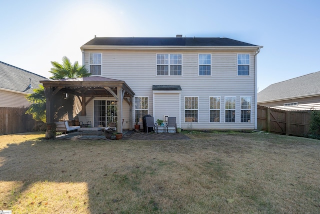 back of property with a gazebo, a patio area, and a lawn