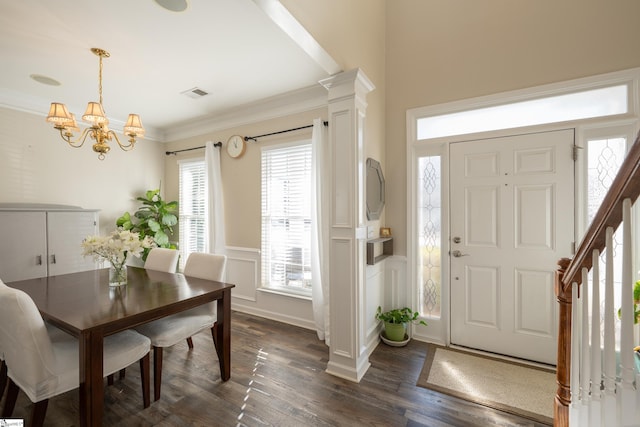 dining space featuring decorative columns, crown molding, dark hardwood / wood-style flooring, and a chandelier