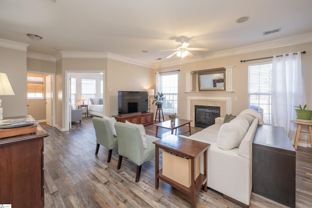 living room featuring hardwood / wood-style flooring, ceiling fan, a healthy amount of sunlight, and a tile fireplace