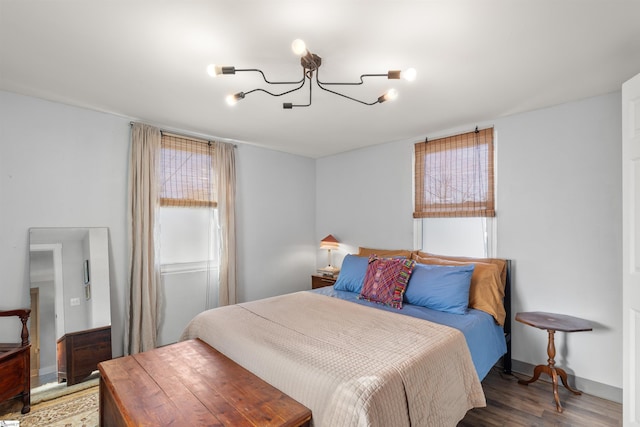 bedroom with hardwood / wood-style flooring and a chandelier