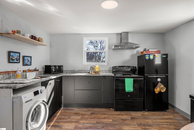 kitchen with wall chimney range hood, dark hardwood / wood-style flooring, washer / clothes dryer, stone countertops, and black appliances