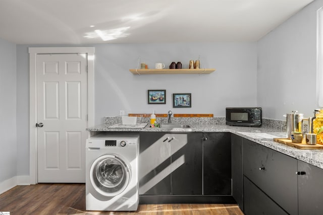 clothes washing area with sink, dark wood-type flooring, and washer / dryer