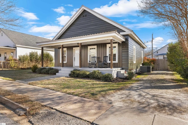 bungalow with central AC, a front lawn, and covered porch