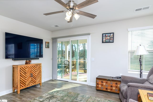 living room with dark hardwood / wood-style floors and ceiling fan