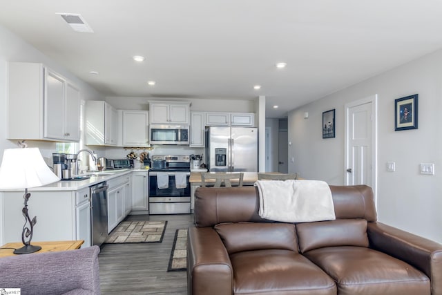 kitchen featuring appliances with stainless steel finishes, dark hardwood / wood-style floors, white cabinetry, and sink