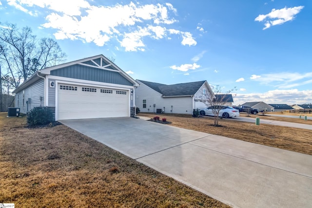 view of front facade featuring cooling unit, a garage, and a front yard