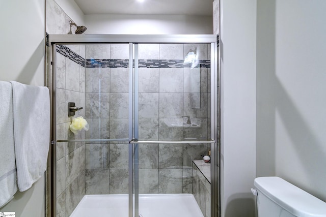 bathroom with toilet and an enclosed shower