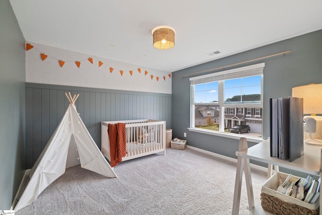 bedroom with carpet and a nursery area