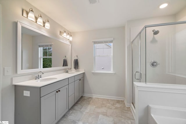 bathroom featuring vanity, plenty of natural light, and a shower with shower door