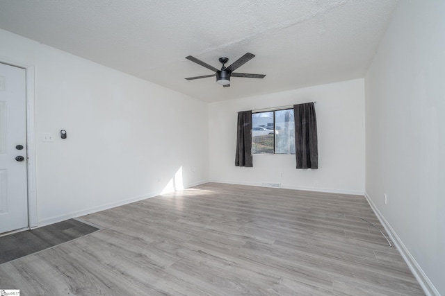 unfurnished room featuring ceiling fan, light hardwood / wood-style floors, and a textured ceiling