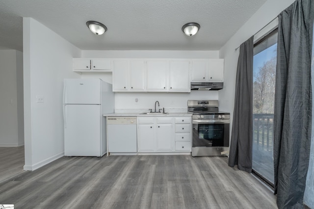 kitchen with white appliances, white cabinets, sink, light wood-type flooring, and a textured ceiling