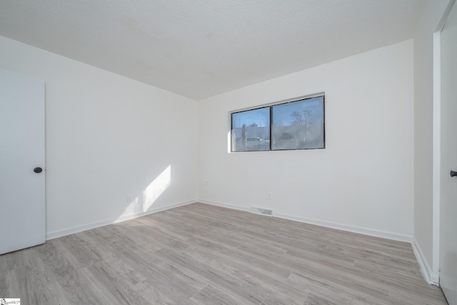 empty room with light hardwood / wood-style flooring