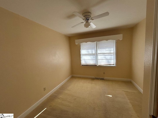 unfurnished room with light colored carpet and ceiling fan