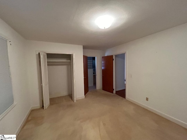 unfurnished bedroom with carpet flooring, a closet, and a textured ceiling