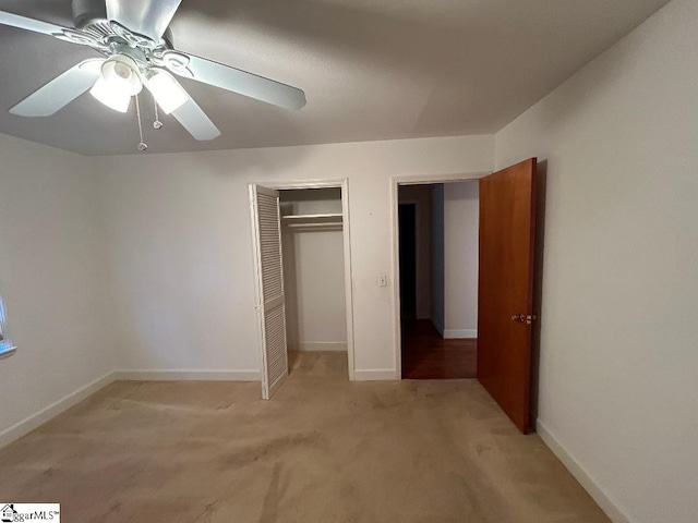 unfurnished bedroom featuring ceiling fan, a closet, and light carpet