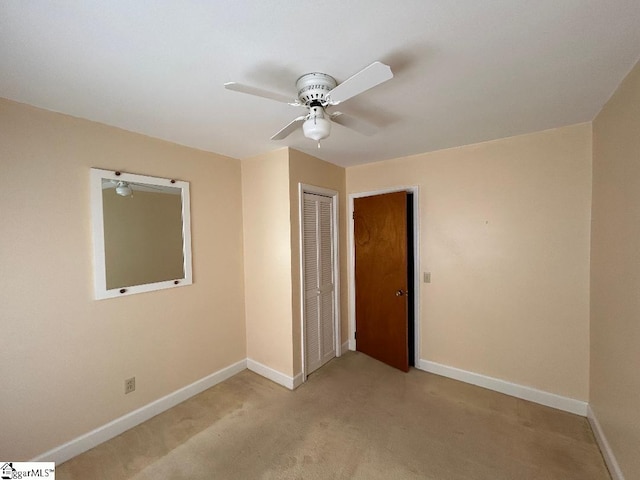 unfurnished bedroom with ceiling fan, a closet, and light colored carpet