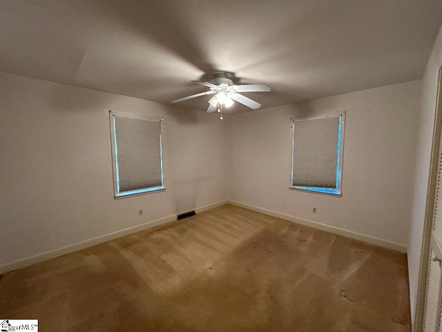 carpeted spare room with ceiling fan