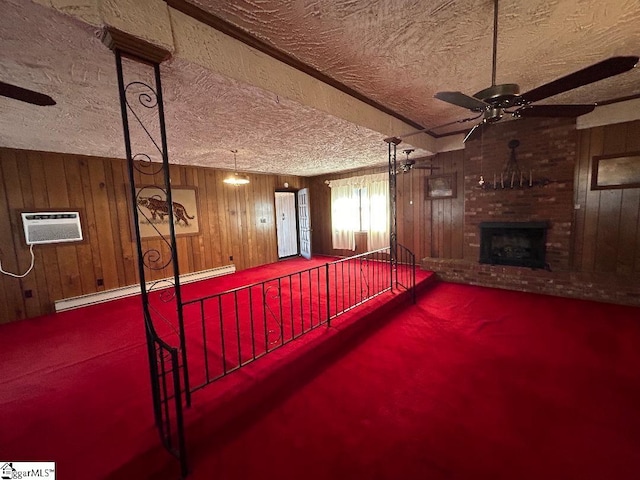 interior space featuring ceiling fan, a brick fireplace, a baseboard heating unit, wood walls, and a textured ceiling