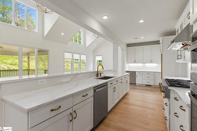 kitchen featuring sink, light stone counters, decorative backsplash, white cabinets, and appliances with stainless steel finishes