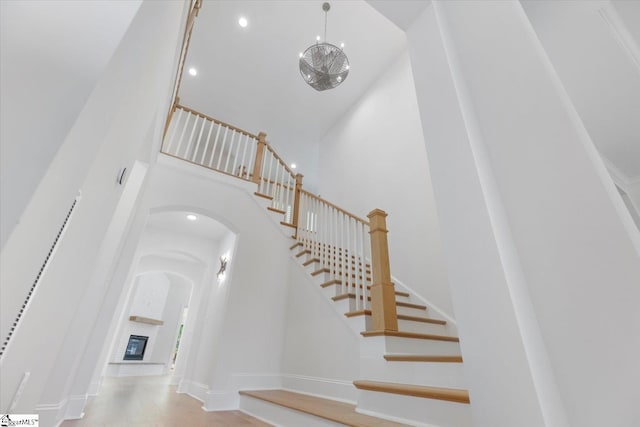 stairway featuring a high ceiling and a brick fireplace