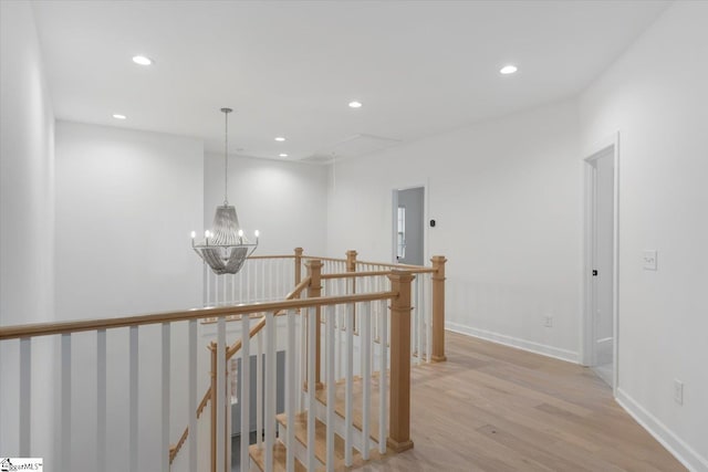 hall with light hardwood / wood-style flooring and a chandelier