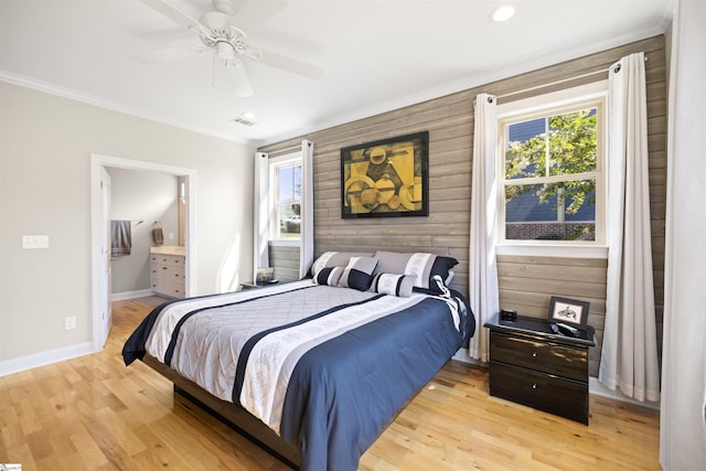 bedroom featuring ceiling fan, crown molding, wood walls, and light hardwood / wood-style floors