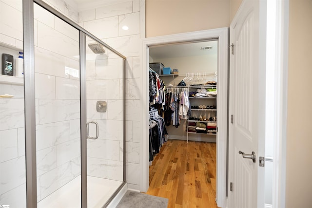 bathroom featuring hardwood / wood-style floors and walk in shower