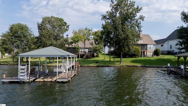 view of dock with a yard and a water view