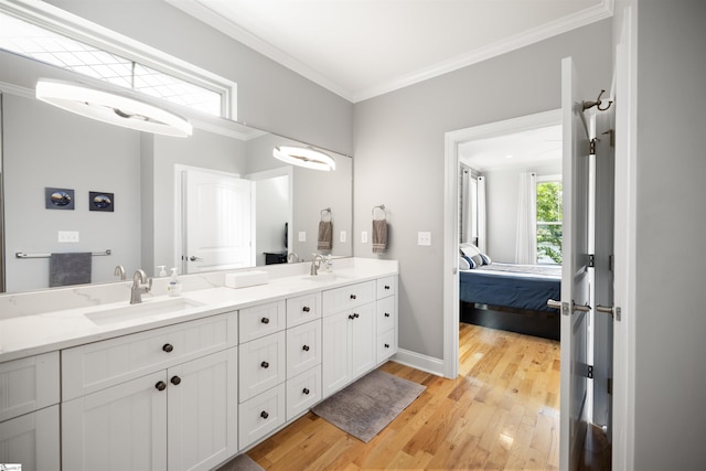 bathroom featuring hardwood / wood-style flooring, ornamental molding, and vanity