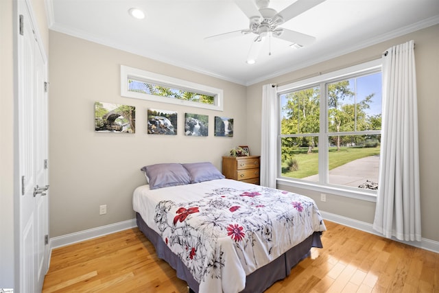 bedroom with ceiling fan, ornamental molding, and hardwood / wood-style floors