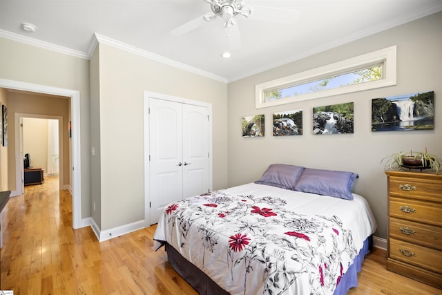 bedroom with light hardwood / wood-style flooring, ceiling fan, a closet, and ornamental molding