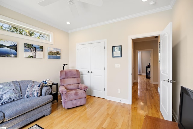 living room featuring ceiling fan, crown molding, and light hardwood / wood-style floors