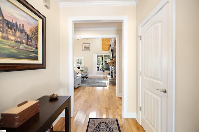 hall with light hardwood / wood-style flooring and crown molding