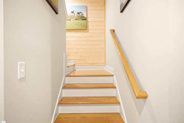 staircase featuring wood walls