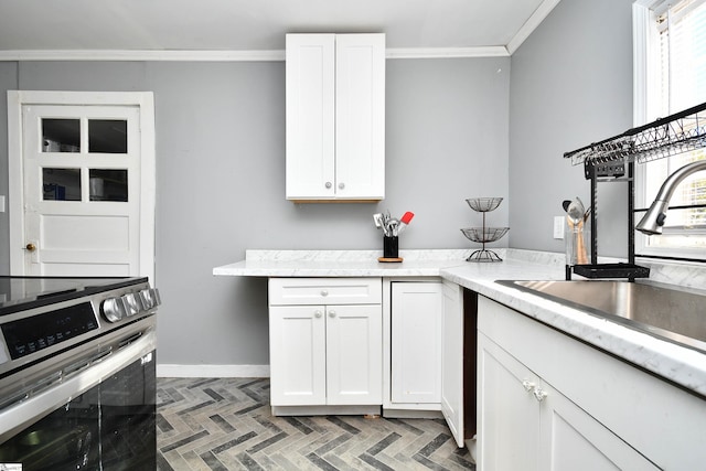 kitchen with stainless steel electric range, dark parquet flooring, white cabinets, sink, and ornamental molding