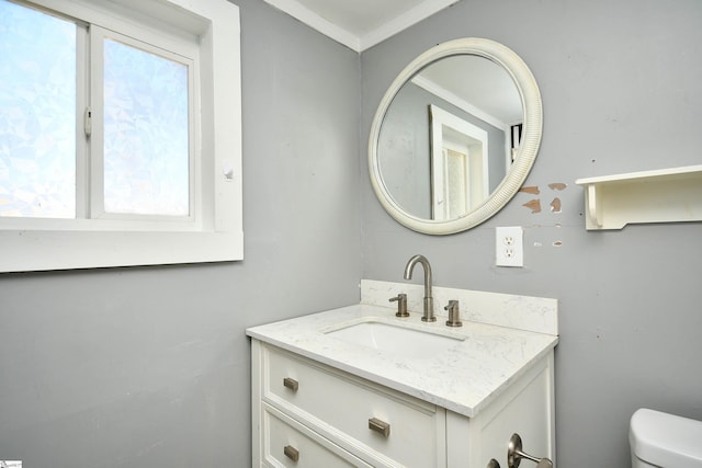 bathroom with crown molding, vanity, and toilet