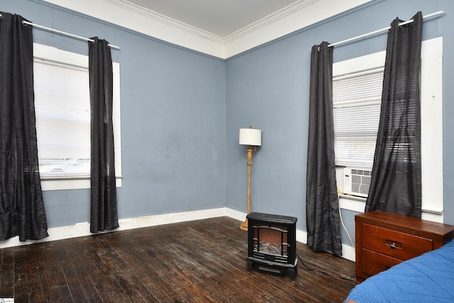 bedroom featuring wood-type flooring, a wood stove, crown molding, and multiple windows